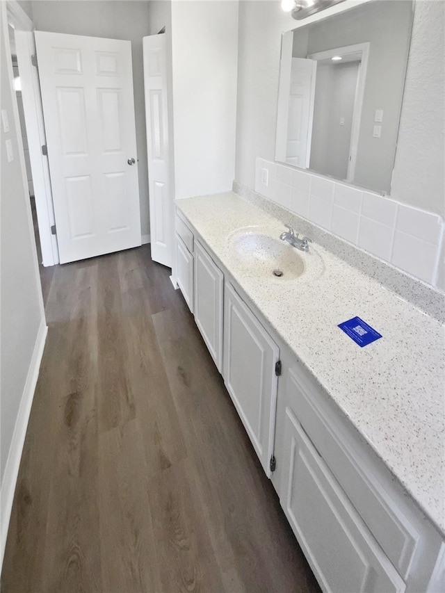 bathroom with backsplash, wood finished floors, and vanity