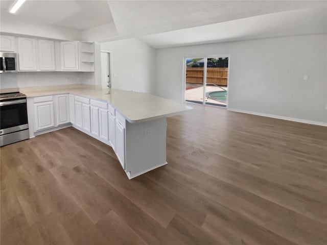 kitchen with a peninsula, open shelves, appliances with stainless steel finishes, and wood finished floors