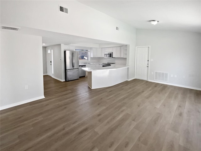 kitchen featuring stainless steel appliances, open floor plan, visible vents, and a peninsula
