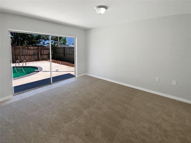 unfurnished room with baseboards and carpet