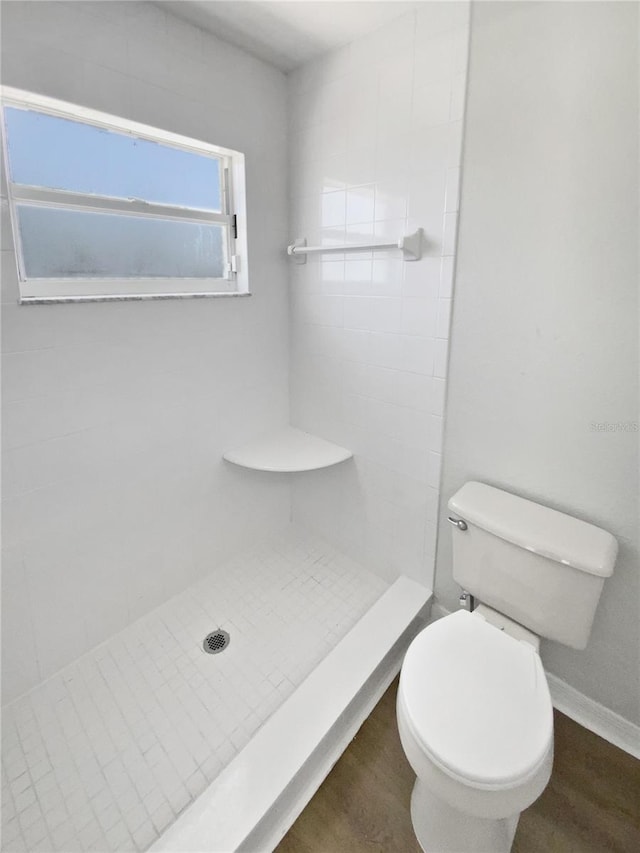 full bath featuring a stall shower, toilet, and wood finished floors