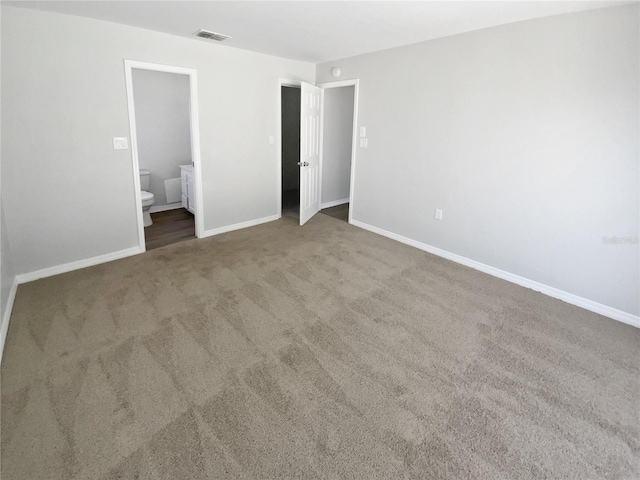 unfurnished bedroom featuring carpet floors, baseboards, visible vents, and connected bathroom