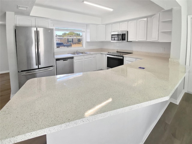 kitchen featuring stainless steel appliances, light stone counters, and a sink