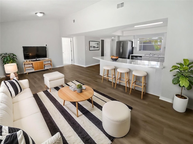 living area featuring baseboards, dark wood-style flooring, and visible vents