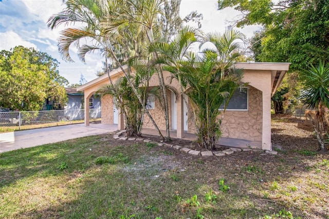 view of front facade with fence, stucco siding, and concrete driveway