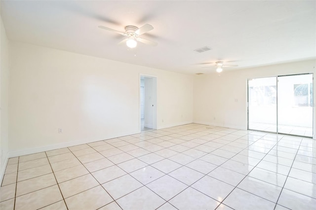 empty room featuring light tile patterned floors, baseboards, ceiling fan, and visible vents