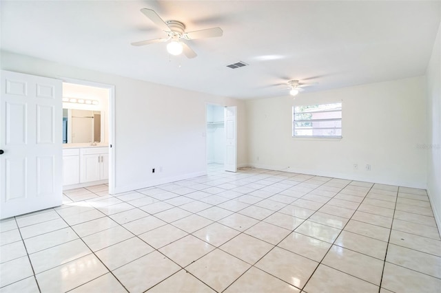 empty room with visible vents, baseboards, ceiling fan, and light tile patterned floors