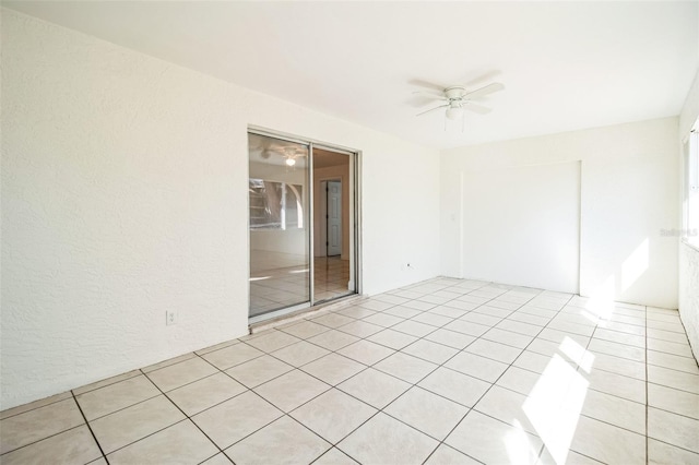 empty room with ceiling fan and light tile patterned flooring