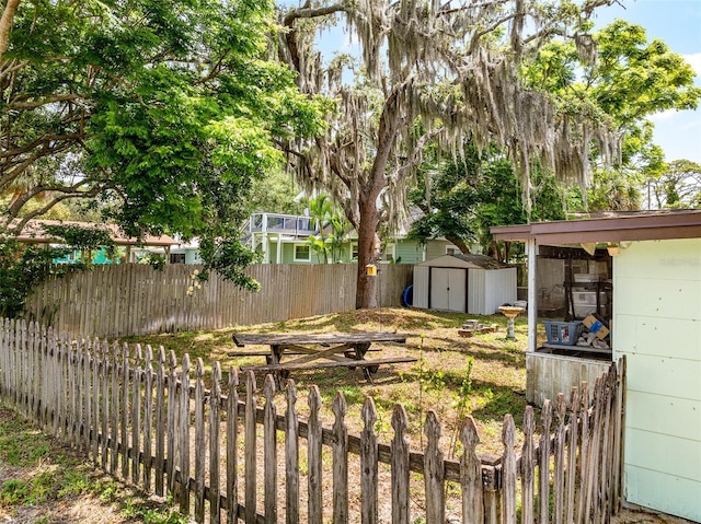 view of yard with a storage shed, an outbuilding, and a fenced backyard
