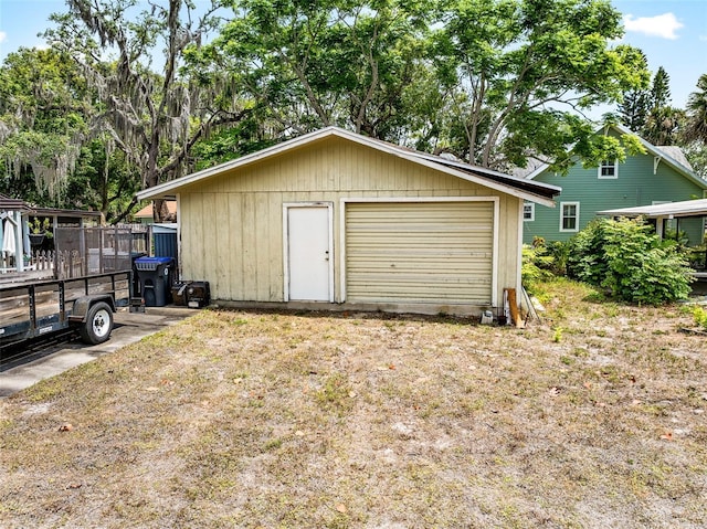 detached garage featuring fence