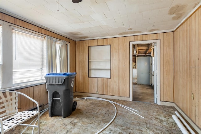 sitting room with baseboards, wooden walls, and built in shelves