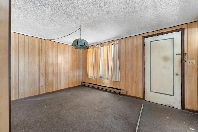 spare room with wooden walls, baseboard heating, and carpet