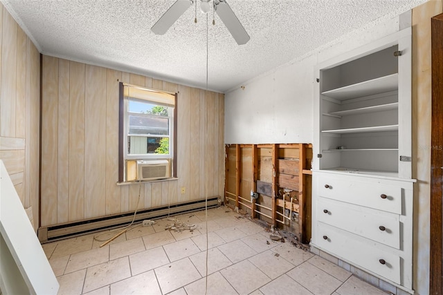 unfurnished bedroom with baseboard heating, cooling unit, a textured ceiling, wood walls, and a ceiling fan