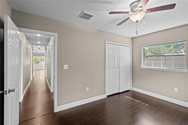 101 E Lauren Ct, Fern Park, FL 32730 - unfurnished bedroom with multiple windows, baseboards, wood finished floors, a closet, and a textured ceiling