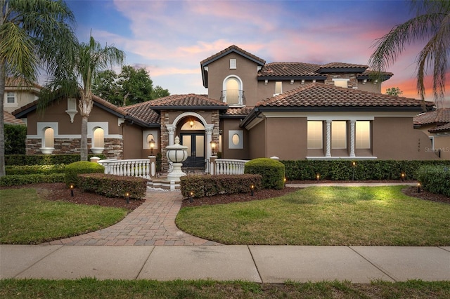 1450 Belfiore Way, Windermere, FL 34786 - mediterranean / spanish-style house with stucco siding, a tiled roof, and a yard