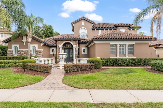 1450 Belfiore Way, Windermere, FL 34786 - mediterranean / spanish-style house with stucco siding, a front lawn, stone siding, and a tile roof