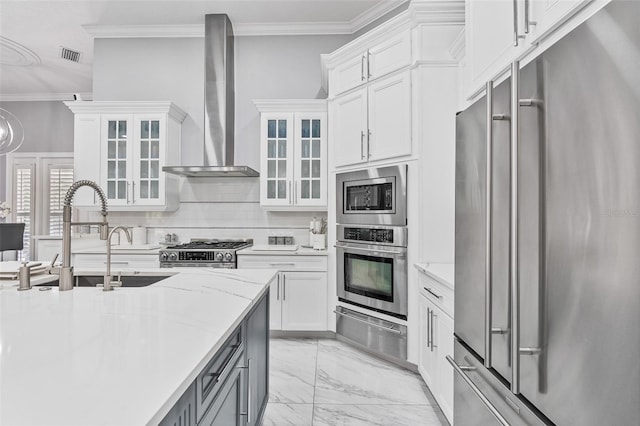 1450 Belfiore Way, Windermere, FL 34786 - kitchen with stainless steel appliances, wall chimney range hood, a warming drawer, crown molding, and light marble finish floors