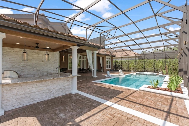 1450 Belfiore Way, Windermere, FL 34786 - view of pool with an outdoor kitchen, a patio, a pool with connected hot tub, glass enclosure, and ceiling fan