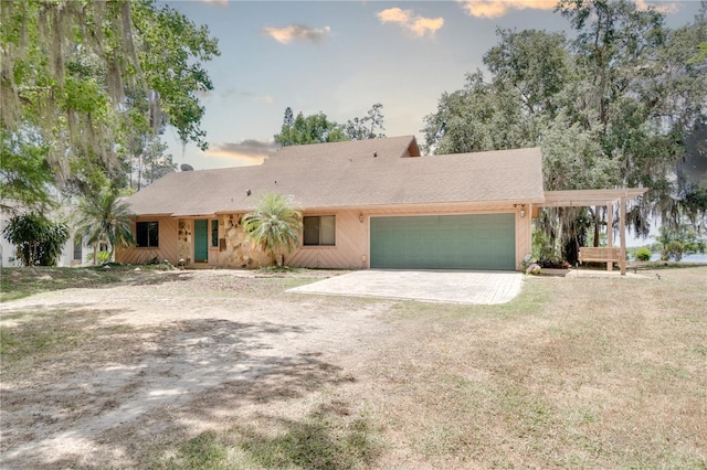 ranch-style home featuring a garage, driveway, and a front yard