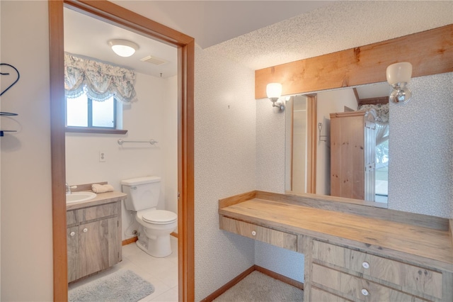 bathroom featuring toilet, baseboards, tile patterned floors, and vanity