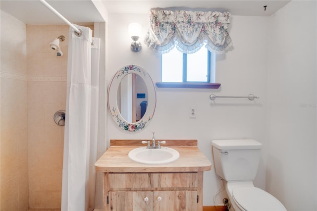 bathroom with toilet, tiled shower, and vanity