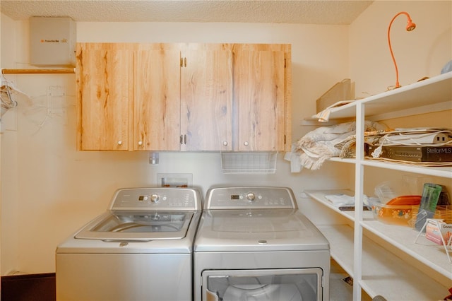 washroom with separate washer and dryer, a textured ceiling, and cabinet space