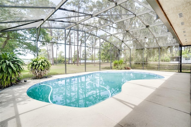 outdoor pool featuring a patio and glass enclosure