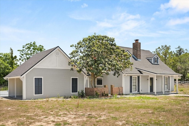 6803 Round Lake Rd, Mount Dora, FL 32757 - back of house with a shingled roof and a chimney