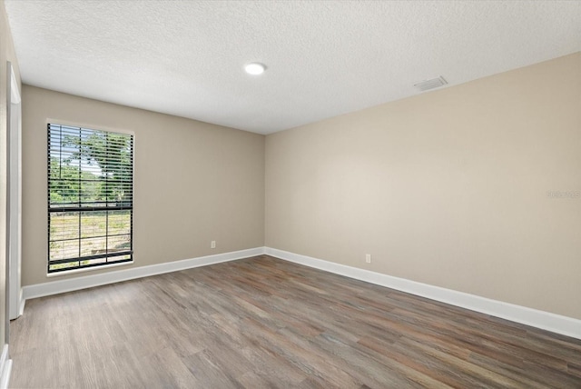 6803 Round Lake Rd, Mount Dora, FL 32757 - unfurnished room featuring wood finished floors, a textured ceiling, and baseboards