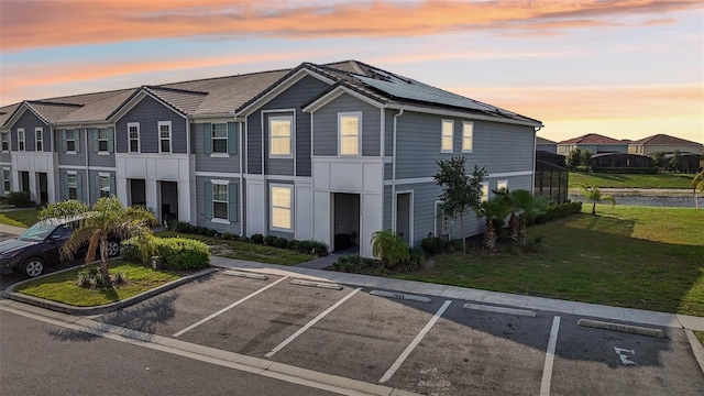 7554 Oak Spring Ln, Davenport, FL 33837 - townhome / multi-family property with uncovered parking, a yard, roof mounted solar panels, and a residential view