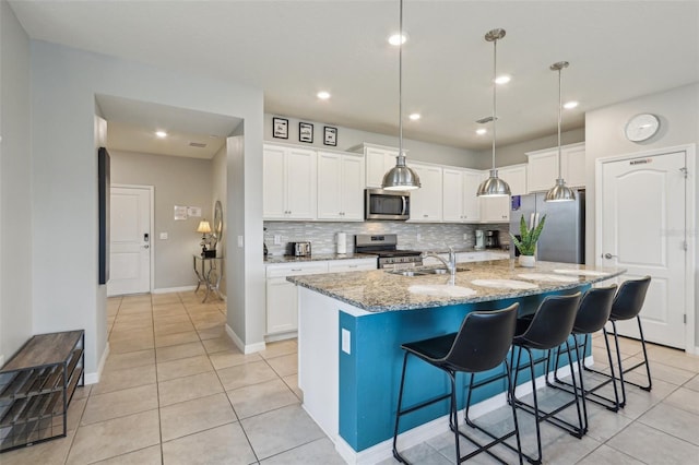 7554 Oak Spring Ln, Davenport, FL 33837 - kitchen featuring stainless steel appliances, a sink, light tile patterned floors, backsplash, and white cabinets