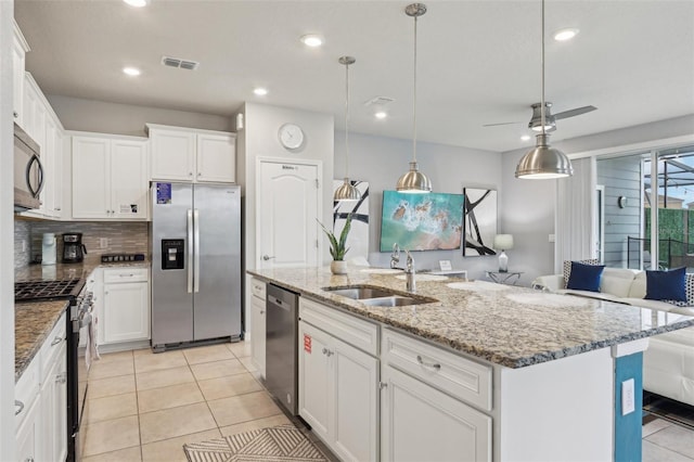 7554 Oak Spring Ln, Davenport, FL 33837 - kitchen featuring appliances with stainless steel finishes, a sink, white cabinets, light tile patterned flooring, and recessed lighting