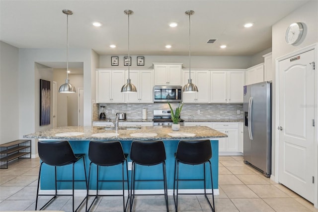 7554 Oak Spring Ln, Davenport, FL 33837 - kitchen featuring appliances with stainless steel finishes, backsplash, white cabinets, light tile patterned flooring, and recessed lighting