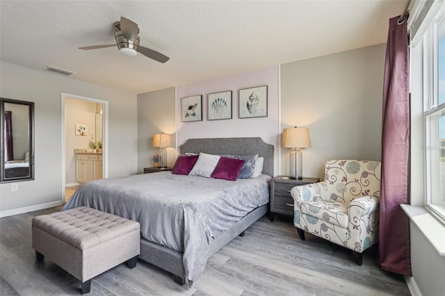7554 Oak Spring Ln, Davenport, FL 33837 - bedroom featuring wood finished floors, baseboards, ceiling fan, and connected bathroom
