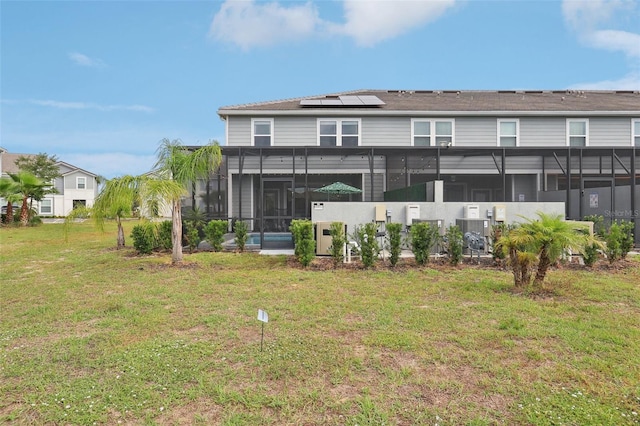7554 Oak Spring Ln, Davenport, FL 33837 - rear view of property with a sunroom, a lawn, and roof mounted solar panels