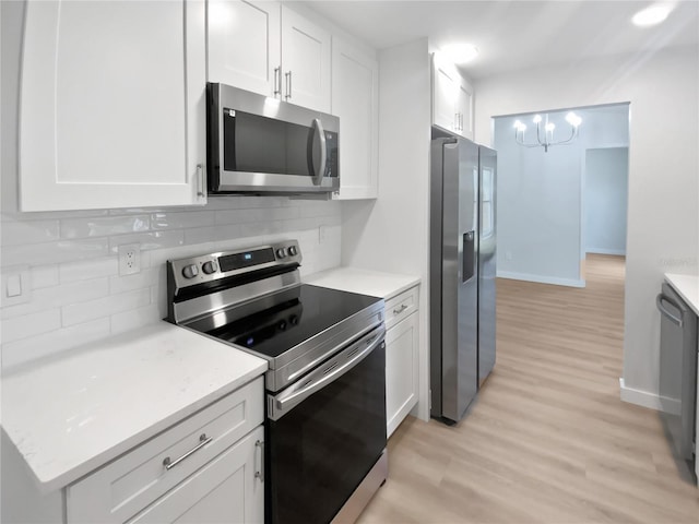 kitchen featuring decorative backsplash, stainless steel appliances, and white cabinetry