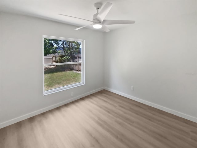 spare room with baseboards, a ceiling fan, and wood finished floors