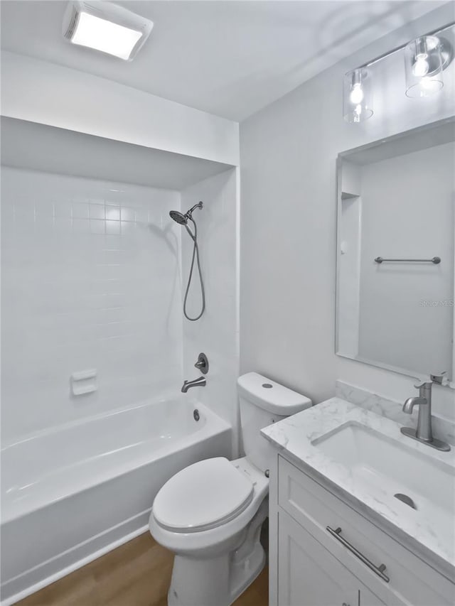 bathroom featuring shower / bathtub combination, toilet, wood finished floors, and vanity