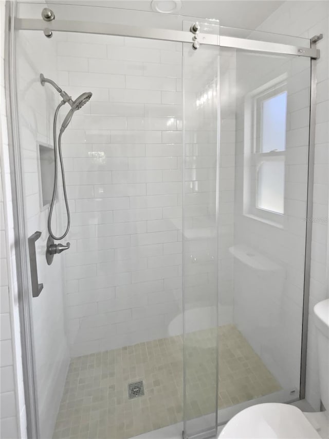 bathroom with toilet and a shower stall