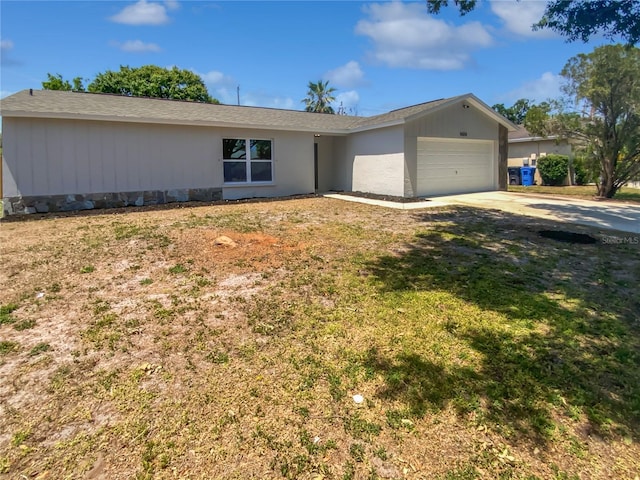 ranch-style home with an attached garage, a front lawn, and concrete driveway