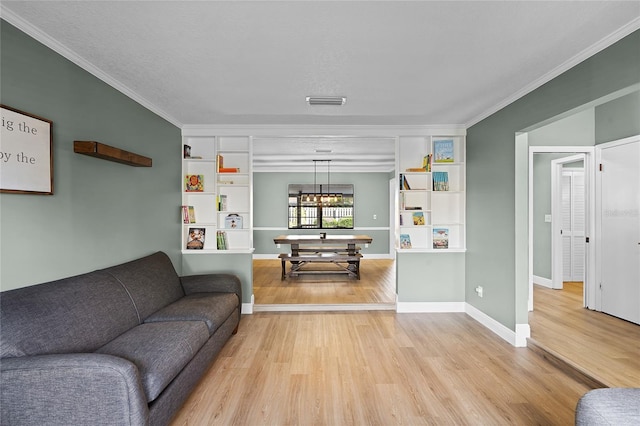 living room with crown molding, baseboards, and light wood finished floors