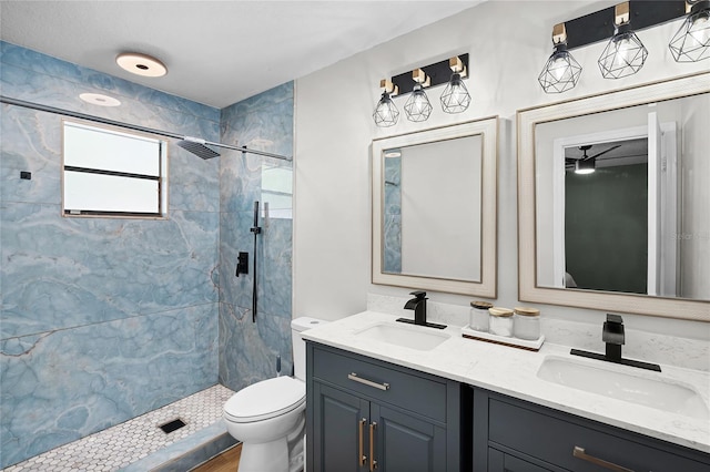 bathroom featuring a sink, a stall shower, toilet, and double vanity
