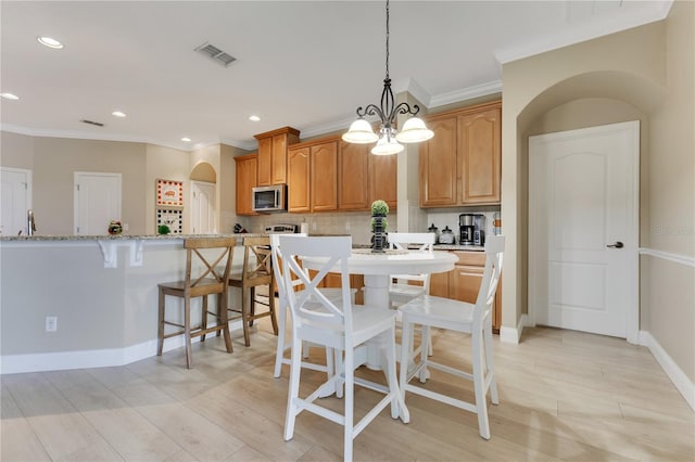 dining space featuring crown molding, recessed lighting, visible vents, and light wood-style flooring