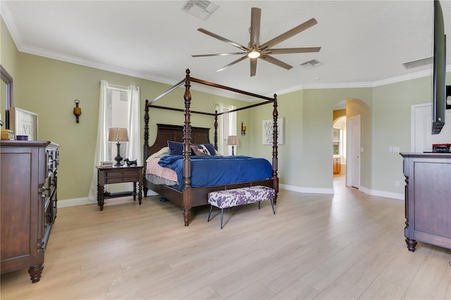 bedroom with visible vents, arched walkways, light wood-style flooring, and baseboards