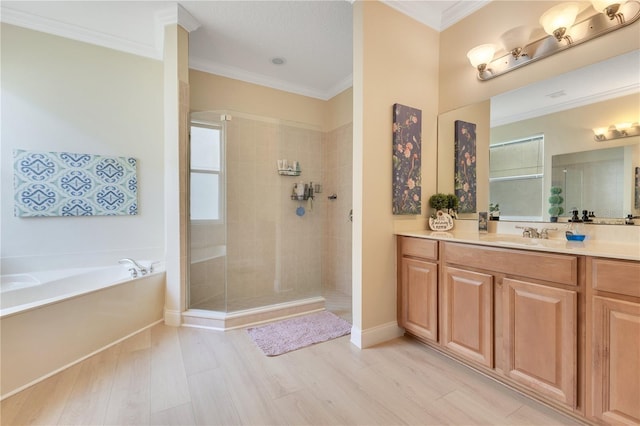 full bathroom with a tile shower, vanity, wood finished floors, ornamental molding, and a garden tub