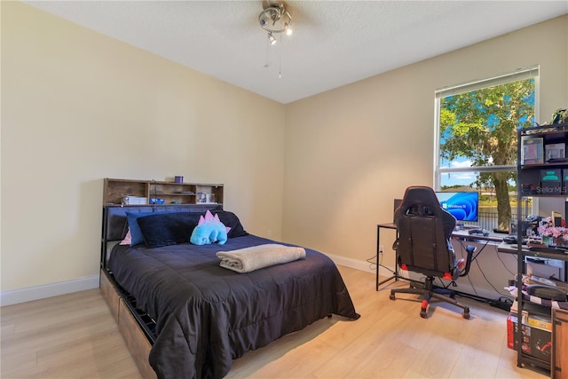 bedroom with baseboards and wood finished floors