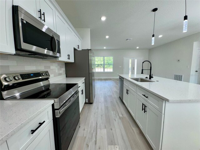 kitchen featuring appliances with stainless steel finishes, a sink, light wood-style floors, recessed lighting, and visible vents
