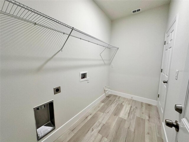 washroom with washer hookup, laundry area, light wood-style flooring, electric dryer hookup, and visible vents
