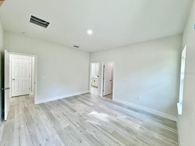 unfurnished room featuring visible vents, baseboards, and light wood-style floors
