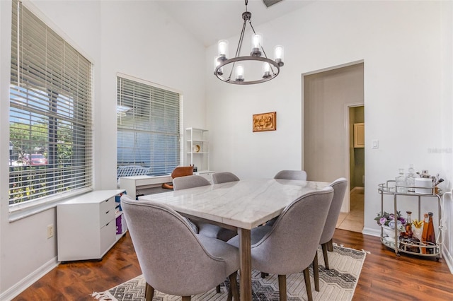 dining space featuring baseboards, dark wood-style flooring, a chandelier, and high vaulted ceiling